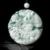 Round carved jade pendant with green and white mountain landscape design on a black cord