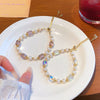 Two adjustable bracelets with pearls and crystal beads on a white plate