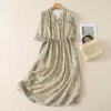Long floral print dress hanging on a wooden hanger against a plain wall