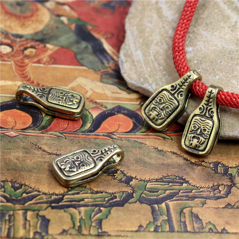 Antique brass pendant with Zakiram Goddess engraving on a red cord