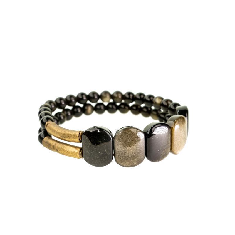 Close up of a double strand bracelet with black beads and gold accents on a wrist