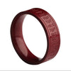 Close-up of a red cinnabar ring with engraved text on the outer band