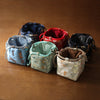 Collection of colorful fabric drawstring bags on a wooden table