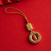 Gold-tone hanging charm with a Buddha figure and red bead against a red background