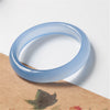 Close-up of a light blue agate bangle on a textured surface