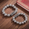 Close up of silver plated Pixiu bracelet with Bagua patterned beads on wood