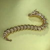 Gold-tone dragon bracelet with detailed scales and head resting on a light surface