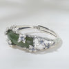 Close up of a sterling silver ring with a curved green jade stone and butterfly accents