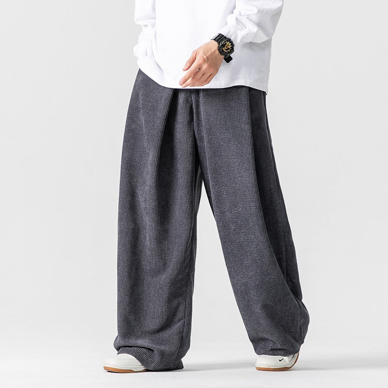 Man wearing grey wide leg corduroy pants with a white shirt