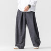 Man wearing grey wide leg corduroy pants with a white shirt
