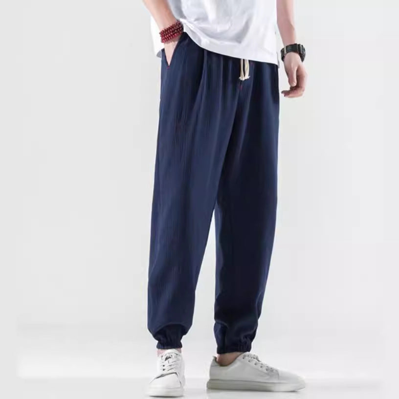 Model wearing navy blue loose fit linen pants with drawstring waist