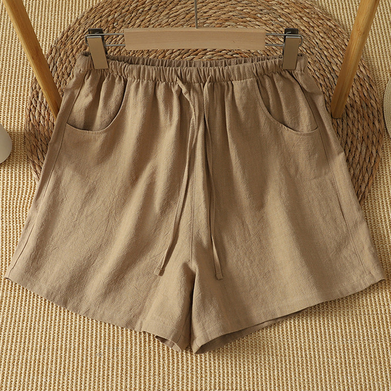 Khaki cotton shorts with drawstring waist hanging on a wooden hanger