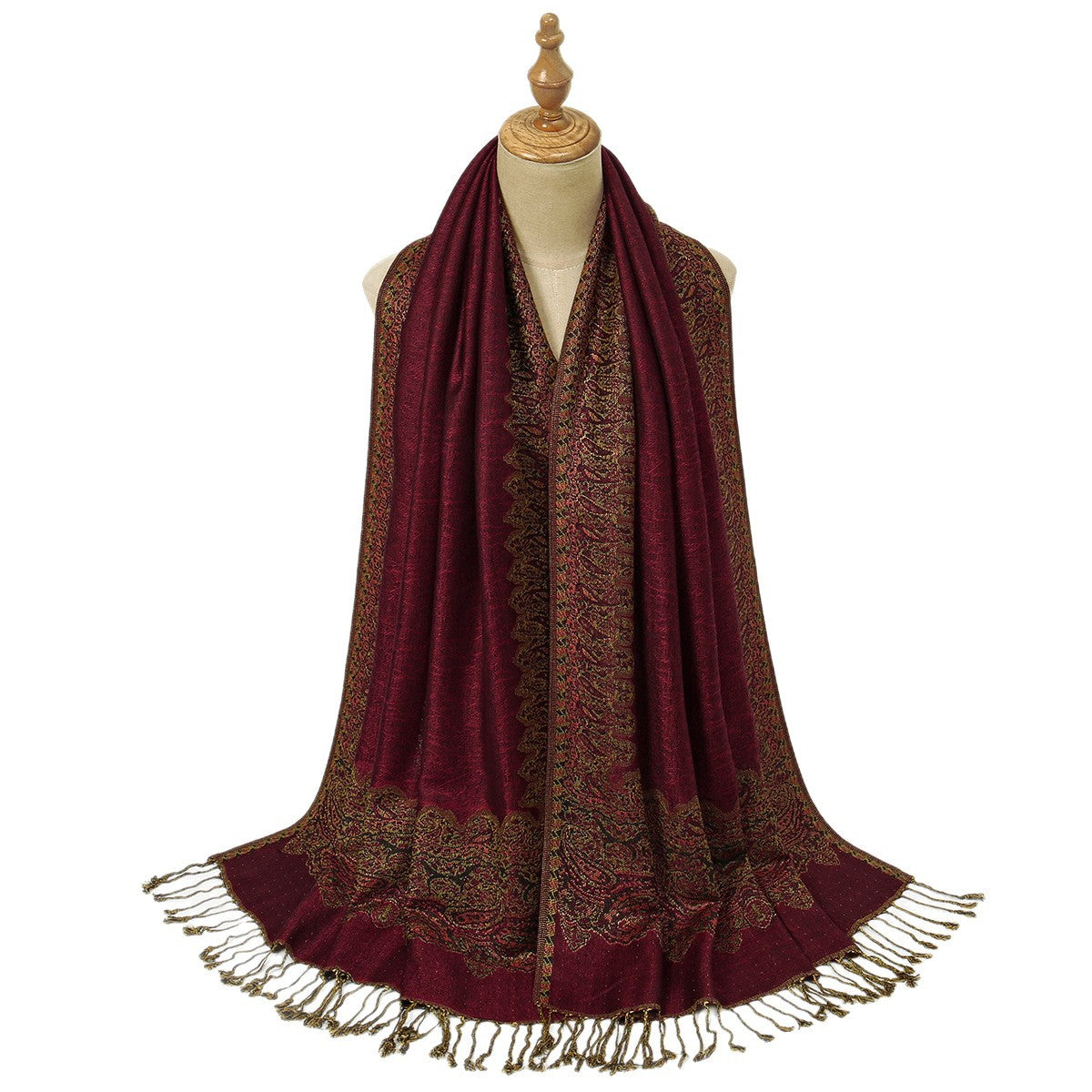 Burgundy floral jacquard scarf with tassels draped over a coat
