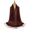 Burgundy floral jacquard scarf with tassels draped over a coat