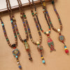 Long handmade wood bead necklace with colorful accents and an alloy pendant