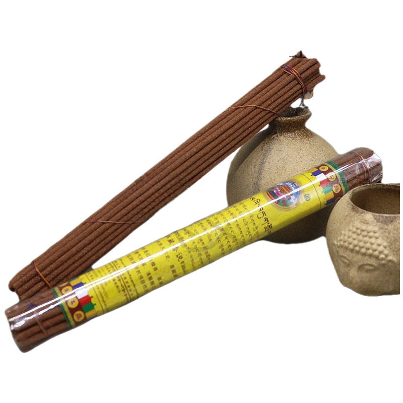 Bundle of brown incense sticks next to a yellow package and ceramic holders