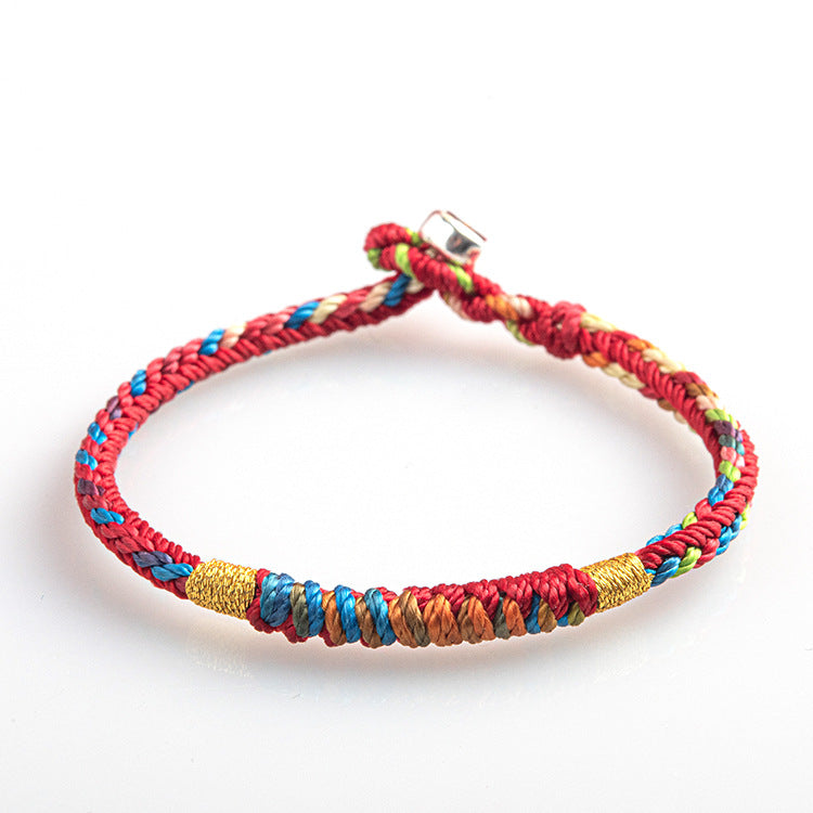 Close-up of a red multicolored woven bracelet with gold tone beads on a white background