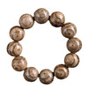 Close up of a wooden bracelet with large round beads showing dark striped grain patterns