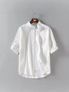 White men's linen-blend shirt with stand collar hanging on a wooden hanger