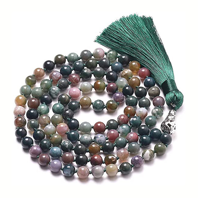 Coiled multi-colored natural stone mala necklace with a green tassel on a white background