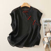 Black sleeveless cotton linen top with red frog buttons on a hanger