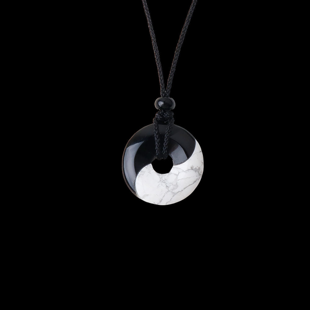Two necklaces with black and white yin yang pendants on black cords