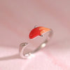 Close up of a silver tone adjustable ring with an orange and red koi fish design on a woman's hand