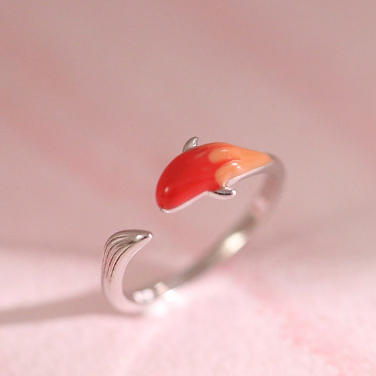 Close up of a silver tone adjustable ring with an orange and red koi fish design on a woman's hand