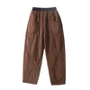Brown thickened harem pants with pockets laid flat on a white surface