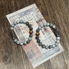 Two beaded bracelets with a black and white Dzi bead resting on vintage paper