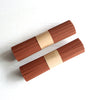 Two bundles of brown straight incense sticks wrapped in paper bands