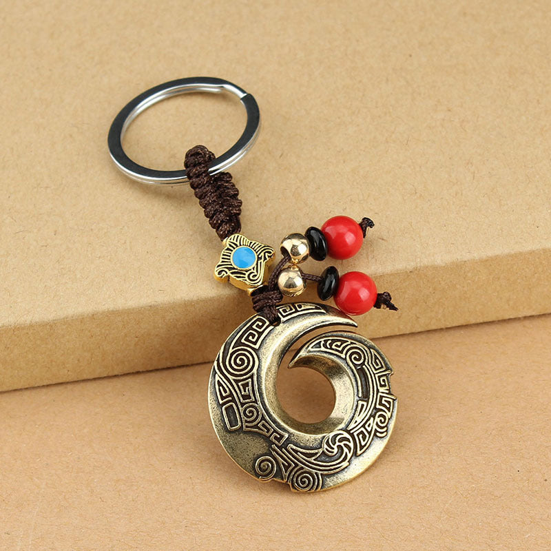 Antique copper key chain with dragon hook pendant and red beads attached to a car key