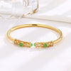 Gold-Tone Open Cuff Bangle with Green Stone and Filigree