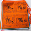 Stack of colorful prayer flags showing orange blue and pink panels with horse motifs