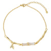 Close up of a gold tone copper anklet with bamboo links worn on an ankle