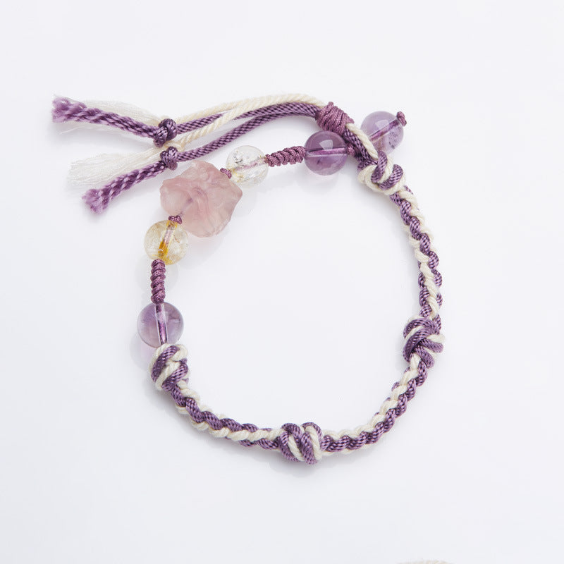 Purple and white woven rope bracelet with pink and purple crystal beads on a white background