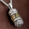 Close up of silver tone copper pendant with gold text on brown background