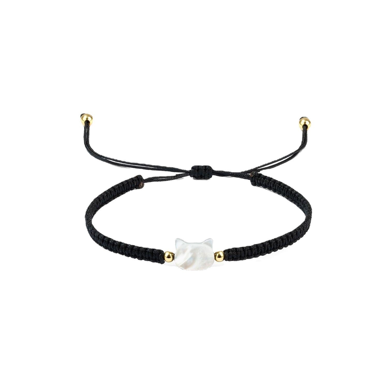 Close up of a black woven bracelet with a white faceless cat head charm