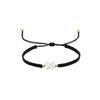 Close up of a black woven bracelet with a white faceless cat head charm