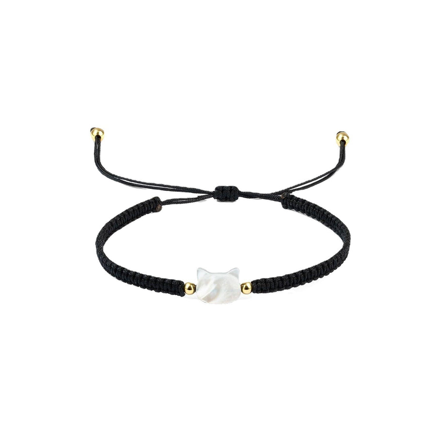Close up of a black woven bracelet with a white faceless cat head charm