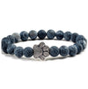 Silver-tone paw print charm on a blue cracked stone beaded bracelet