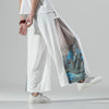 Model wearing white wide leg pants with blue mountain print on the side
