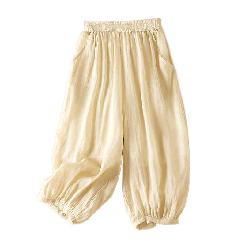 Beige cotton linen harem pants with elastic waist and pockets on white background