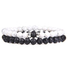 Two stacked beaded bracelets featuring white howlite and black lava rock beads with a silver accent