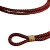 Close-up of a braided red string bracelet with a gold tone button clasp