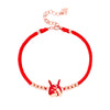 Close up of a red string bracelet with a silver rabbit charm on a wrist