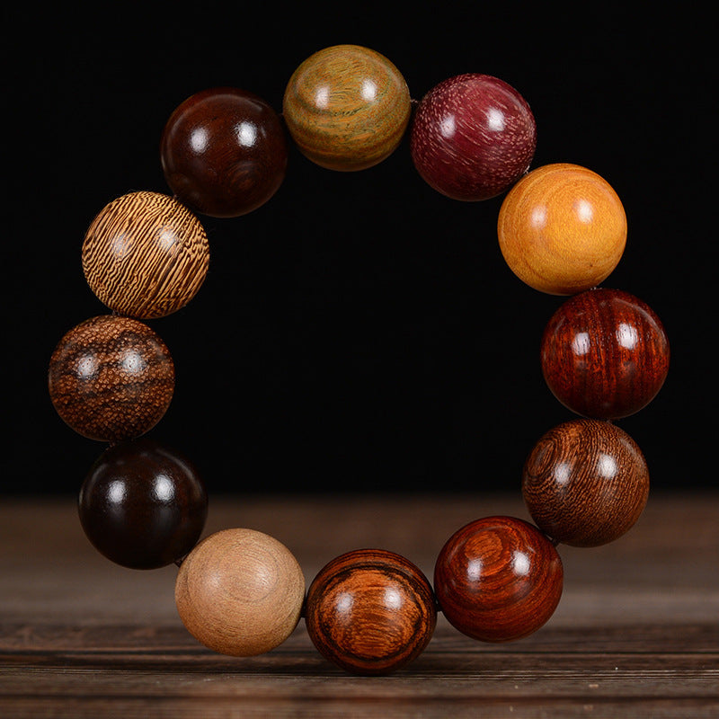 A close up of a multicolored wooden bead bracelet on a dark surface