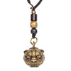 Close up of a brass tiger head pixiu bell keychain resting on a book