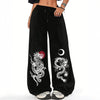Black wide leg pants with white dragon and moon graphics on the legs