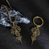 Gold tone stainless steel necklace pendant with lotus and unalome design on a dark textured background